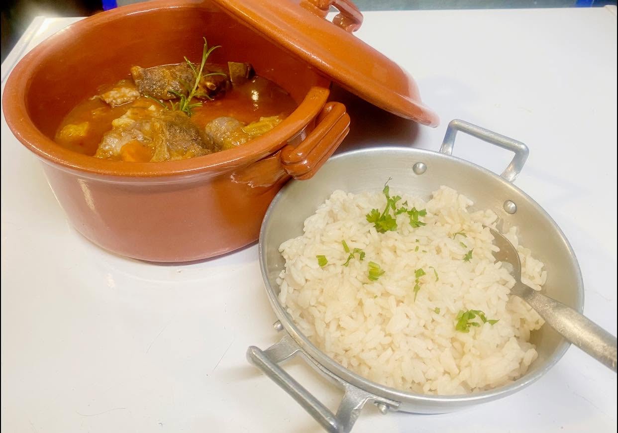 Madeiran beef stew in a clay pot, served with white rice